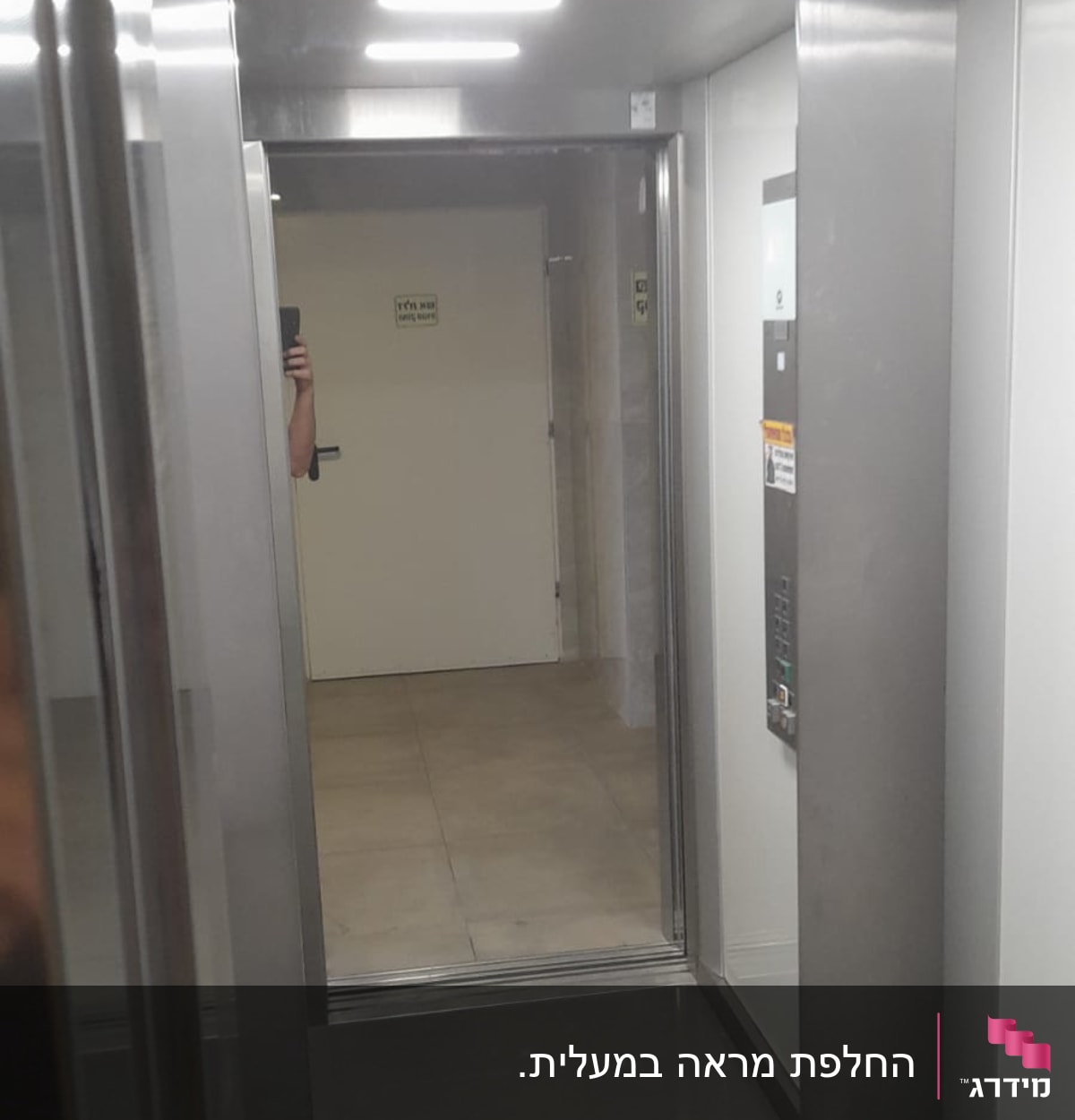 מראה זכוכית במעלית עם השתקפות דלת